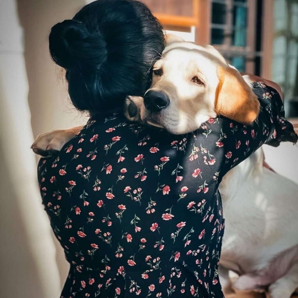 A person hugging a dog Description automatically generated