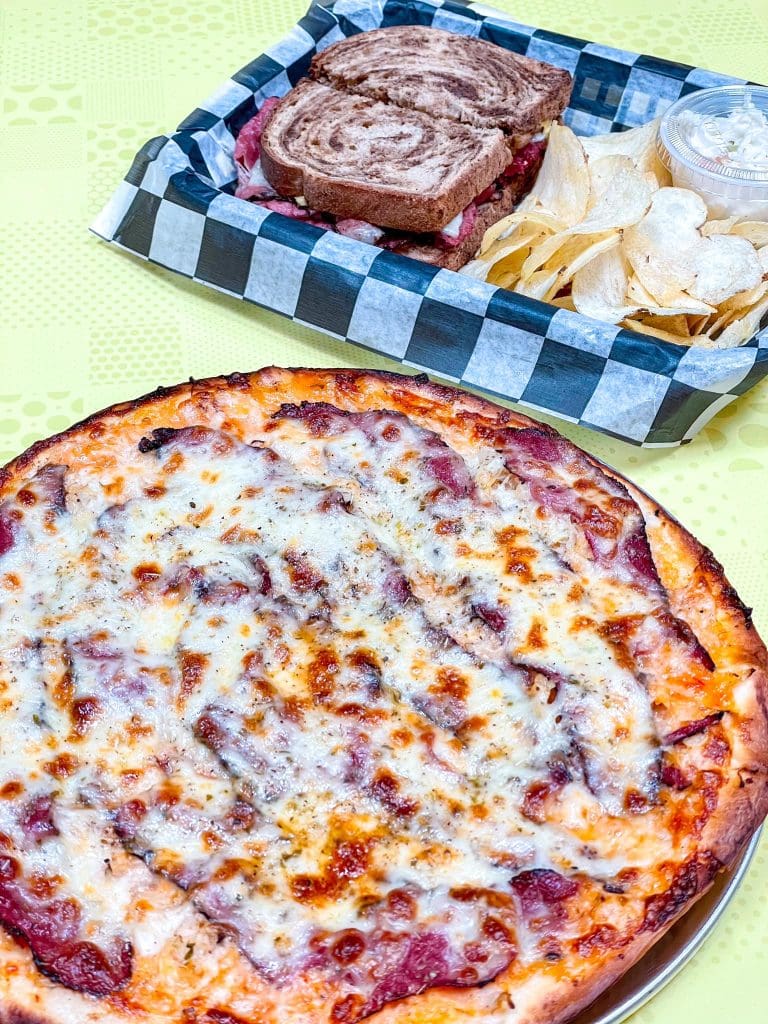 A pizza and a basket of chips

Description automatically generated