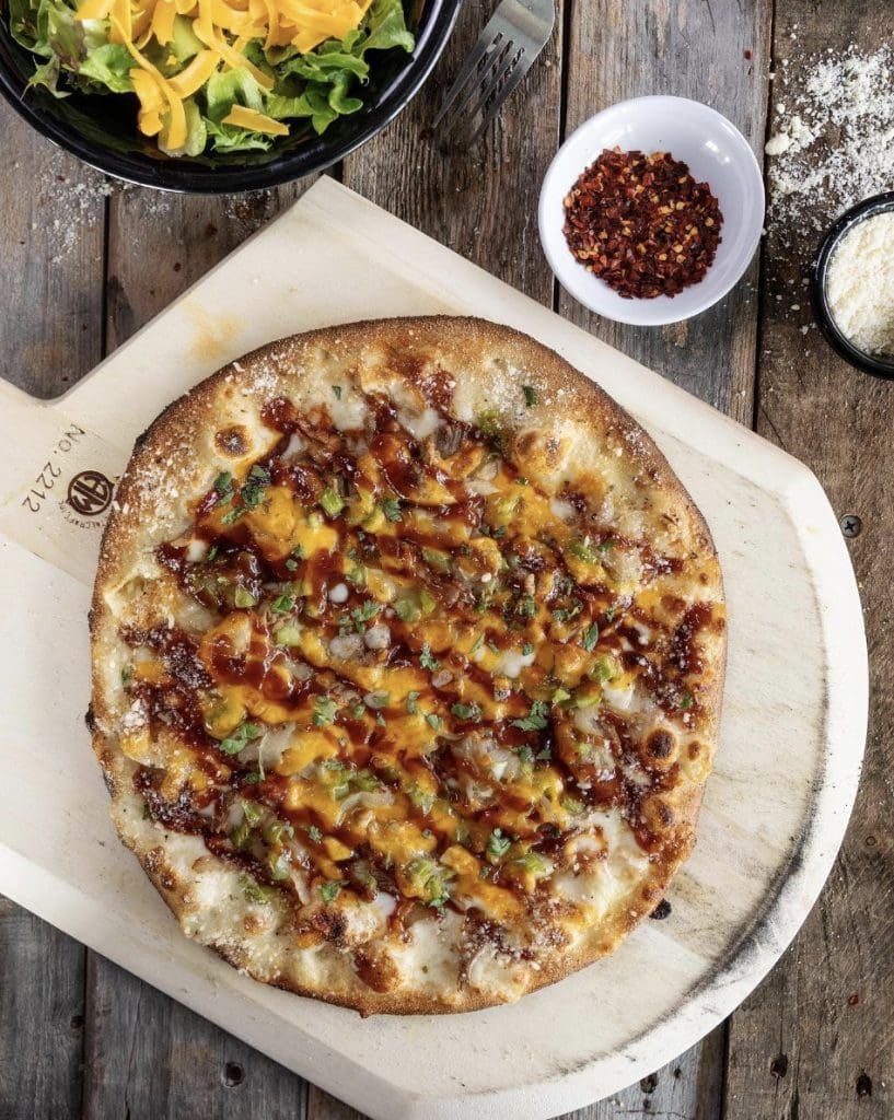 A pizza on a cutting board

Description automatically generated