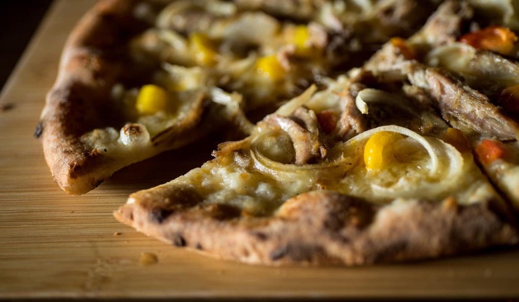 A pizza with corn and cheese

Description automatically generated
