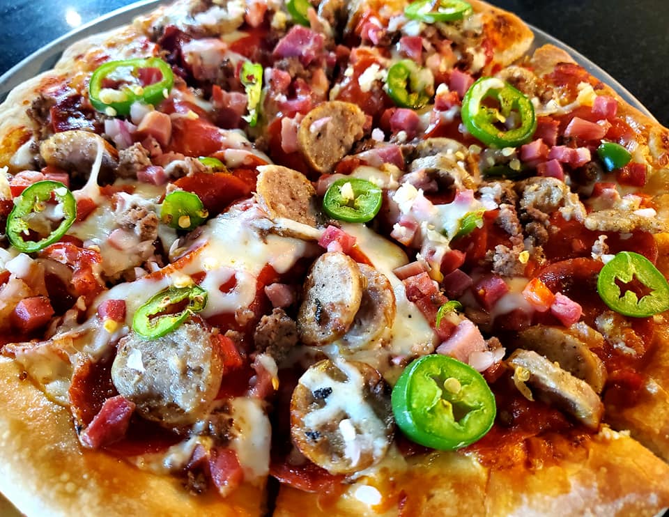 A pizza with jalapenos on it

Description automatically generated