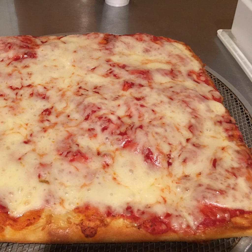 A square pizza on a metal tray

Description automatically generated